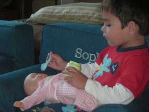 Evan feeding his baby some baby food